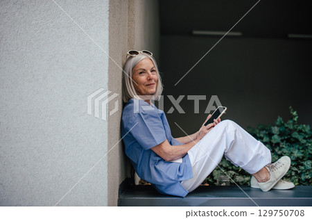 Older nurse resting during hospital shift, taking break. 129750708