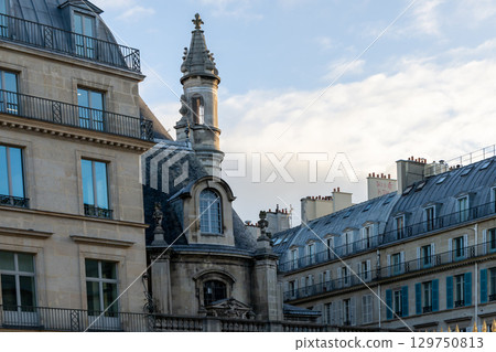 A row of buildings with a central clock tower forms an urban landmark A row of buildings with a central clock tower forms an urban landmark 129750813