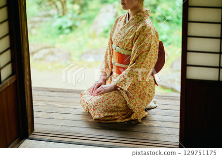 一位身著和服的女子靜靜地站在陽台上 129751175