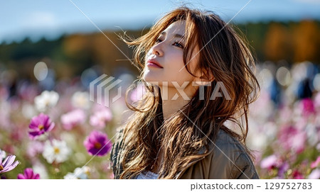 Autumn portrait of a young woman smiling in a cosmos field Autumn portrait of a young woman smiling in a cosmos field 129752783