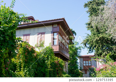 House with a balcony and a tree in front of it House with a balcony and a tree in front of it 129753395