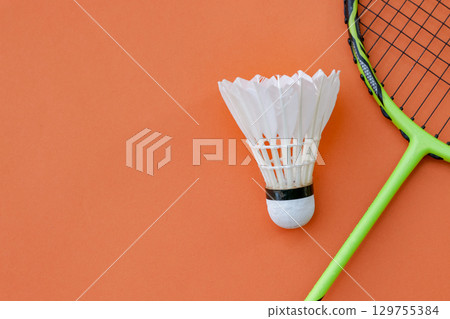 Shuttlecock and Racket on Orange Background 129755384