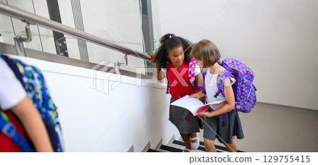 Girl friends talking in school hallway. Banner with copy space. 129755415