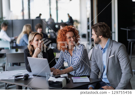 Creative team having discussion over coffee about project strategy. 129755456