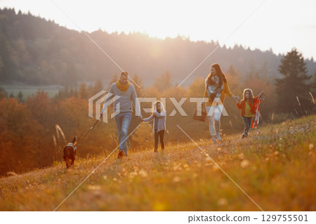 A portrait of young family with two small children in autumn nature at sunset. 129755501