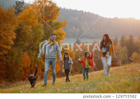 Happy young family with two children in autumn nature at sunset. Happy young family with two children in autumn nature at sunset. 129755502