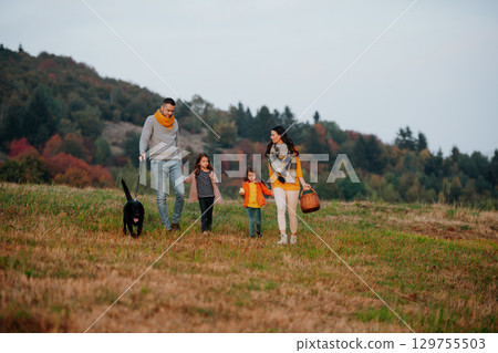 Happy young family with two children in autumn nature at sunset. Happy young family with two children in autumn nature at sunset. 129755503