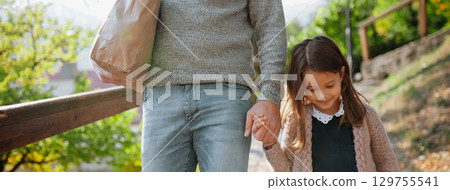 Parent walking child to school on first day, holding hands. 129755541