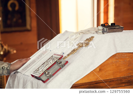 The sacrament of baptism in the Orthodox Church. Prayer books and a crucifix on the table The sacrament of baptism in the Orthodox Church. Prayer books and a crucifix on the table 129755560