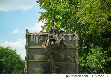 Dirty with spots Truck with hydraulic manipulator for collecting and transporting scrap metal. Crane grab scrap Dirty with spots Truck with hydraulic manipulator for collecting and transporting scrap metal. Crane grab scrap 129755567