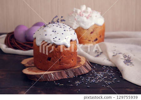 Easter cakes decorated with lavender and marshmallows and painted Easter eggs in a wicker nest 129755939