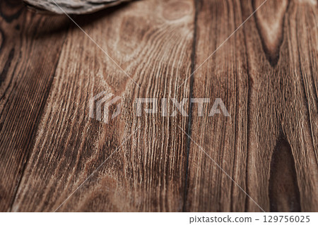 Empty surface of a textured wooden table with rough boards, characteristic longitudinal lines of pine trees, close-up, first-person view with perspective. Blank for artworks with copy space 129756025
