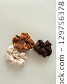 Brown, caramel, and beige satin scrunchies, top view with copy space 129756378