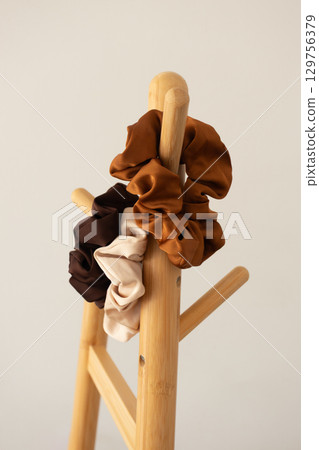 Neutral scrunchies on wooden rack 129756379