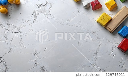 Colorful wooden blocks and toys on gray textured background 129757011