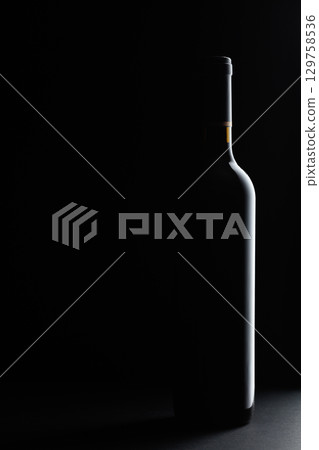 Red wine bottle silhouette over black background. 129758536