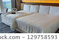 A luxurious bedroom with a bright window and heart-shaped towel art 129758593