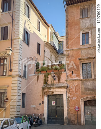 Historic buildings, with different architectural styles and colors, frame a narrow street in Rome, Italy Historic buildings, with different architectural styles and colors, frame a narrow street in Rome, Italy 129760599