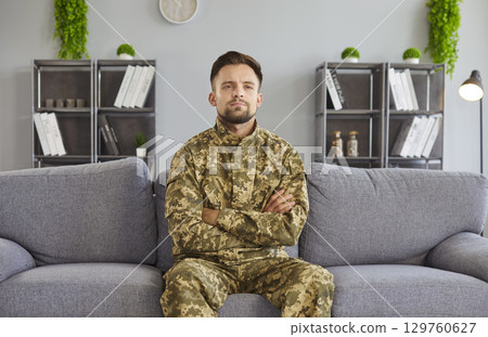 Man wearing military camouflage, arms being crossed, serious, soldier suffers with war memories Man wearing military camouflage, arms being crossed, serious, soldier suffers with war memories 129760627