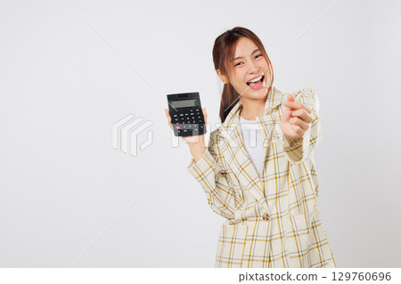 Smiling accountant woman makes finger heart sign while holding calculator, then double-checks tax details on second calculator, managing her budget with care. isolated studio white background 129760696