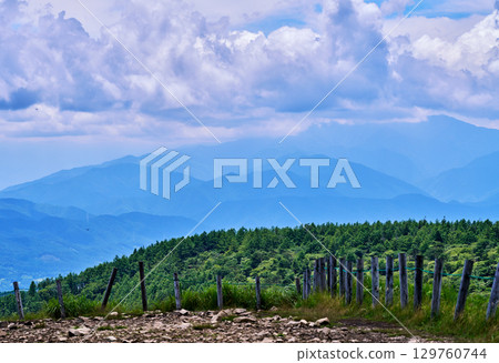 View of the mountains surrounded by fences and forests on the Takabocchi Plateau 129760744