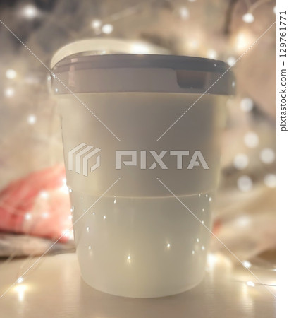 A white container with a lid sits on a table A white container with a lid sits on a table 129761771