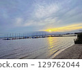 Golden sunset with small clouds over beautiful and calm lake in europe 129762044