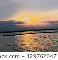 Golden sunset with few clouds over a beautiful and calm lake in Europe 129762047