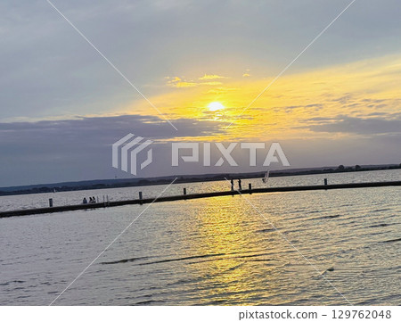 Golden sunset over a beautiful and calm lake in Europe Golden sunset over a beautiful and calm lake in Europe 129762048