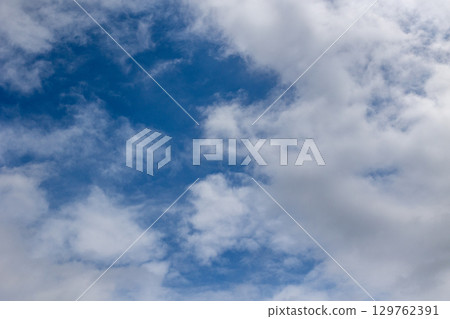Blue sky background peeking through the clouds 129762391