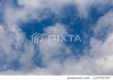 Fluffy clouds and blue sky background material 129762397