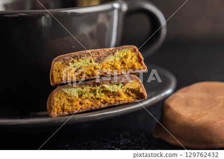 Dubai style chocolate cookies and coffee cup on black table. Dubai style chocolate cookies and coffee cup on black table. 129762432