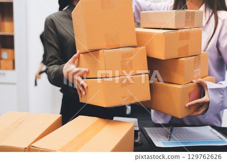 Portrait of Starting small businesses SME owners, two Asian woman check online orders Selling products working with boxs freelance work at home office, sme business online small medium enterprise Portrait of Starting small businesses SME owners, two Asian woman check online orders Selling products working with boxs freelance work at home office, sme business online small medium enterprise 129762626
