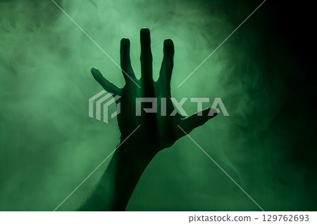 Mysterious hand silhouette and green smoke - background material that expresses fear and anxiety 129762693