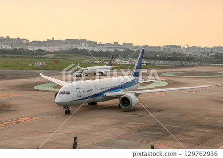 An airplane illuminated by the sunset 129762936