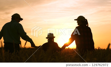 Happy family. Women men child, holding hands, walk through fields wheat sunset. Mother father child daughter hand hand, go to wheat field sunset. happy family outings. silhouette happy family. girl Happy family. Women men child, holding hands, walk through fields wheat sunset. Mother father child daughter hand hand, go to wheat field sunset. happy family outings. silhouette happy family. girl 129762972