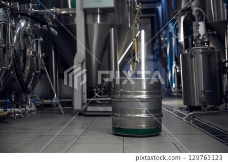 A stainless steel barrel sits on a factory tiled floor, showing design 129763123