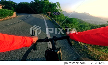 Point of view road cycling in Vercors mountains with scenic view over Grenoble city and surrounding alpine peaks during sunrise Point of view road cycling in Vercors mountains with scenic view over Grenoble city and surrounding alpine peaks during sunrise 129763292