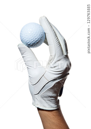 Golf ball held in gloved hand isolated on transparent background, professional sport equipment close-up 129763885