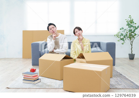一對夫婦正在整理紙箱，表情很困惑 129764039