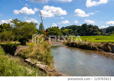 Heavy rain damage in Kajiki Town, Aira City, Kagoshima Prefecture. Stock photo of a bridge collapsed due to flooding of the Amikake River. Heavy rain damage in Kajiki Town, Aira City, Kagoshima Prefecture. Stock photo of a bridge collapsed due to flooding of the Amikake River. 129765621