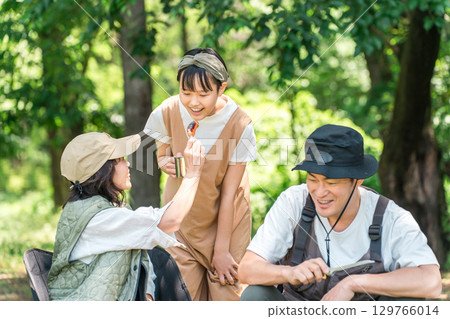 A friendly family enjoying day camping, camping and barbecues at a park or campsite 129766014