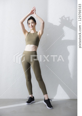 A woman stretching in training wear 129766583