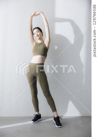 一個穿著訓練服伸展的女人 一個穿著訓練服伸展的女人 129766586