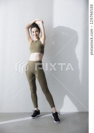 A woman stretching in training wear 129766588