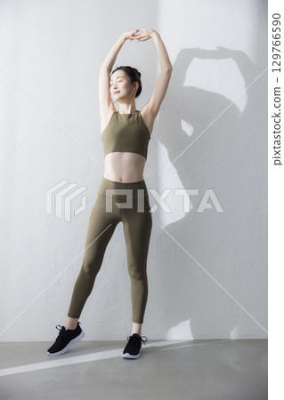 一個穿著訓練服伸展的女人 一個穿著訓練服伸展的女人 129766590