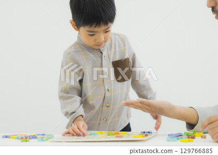Child playing with alphabet blocks 129766885