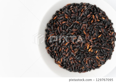 Black rice in a plate on a white background Black rice in a plate on a white background 129767095