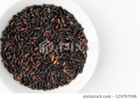 Black rice in a plate on a white background Black rice in a plate on a white background 129767096