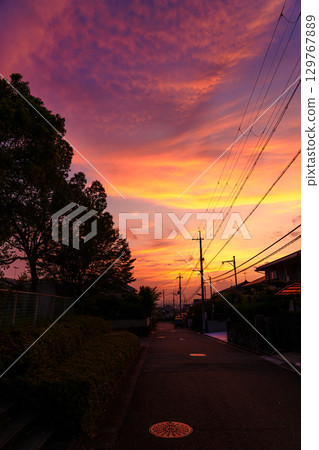 Sunset in a residential area: The sky is dyed crimson red. The sunset paints the cityscape crimson red. Sunset in a residential area: The sky is dyed crimson red. The sunset paints the cityscape crimson red. 129767889